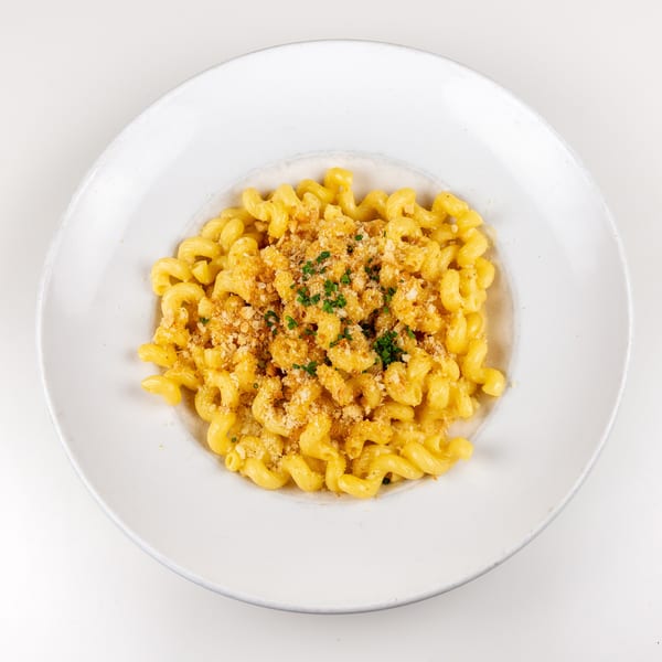 Creamy mac and cheese with cavatappi pasta, topped with golden breadcrumbs and fresh chives.